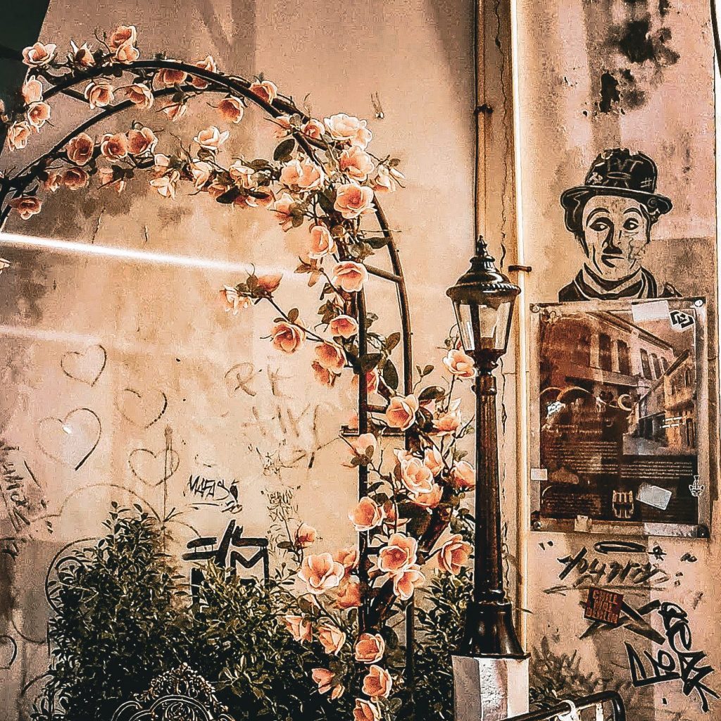 street art chalie chaplin et arche de fleur dans une rue de phuket town