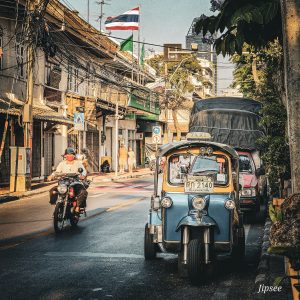 rue de bagkok drapeau thailandais flottant moto et tuk tuk sur la route