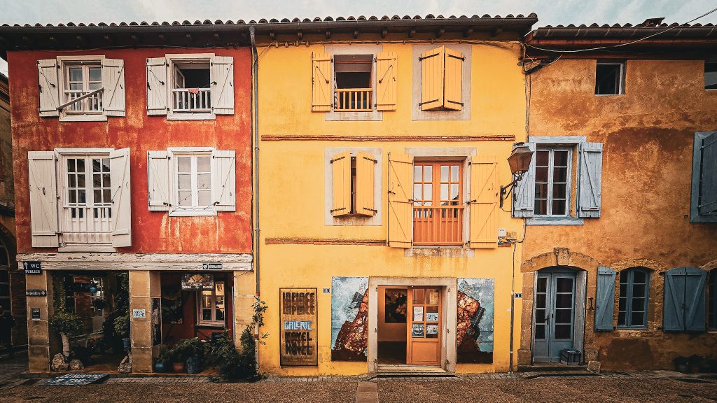 facade colorée de la place pricipale de carla bayle en ariege