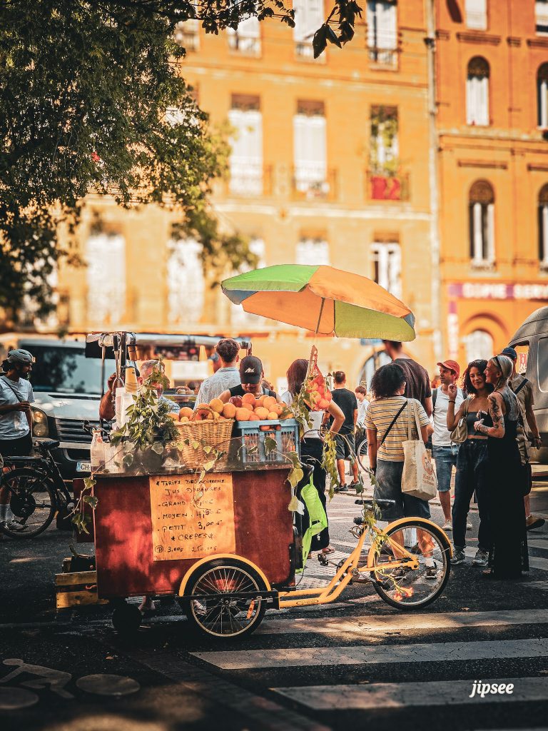 vendeur de jus d'orange frais préssé dans une rue animee de toulouse