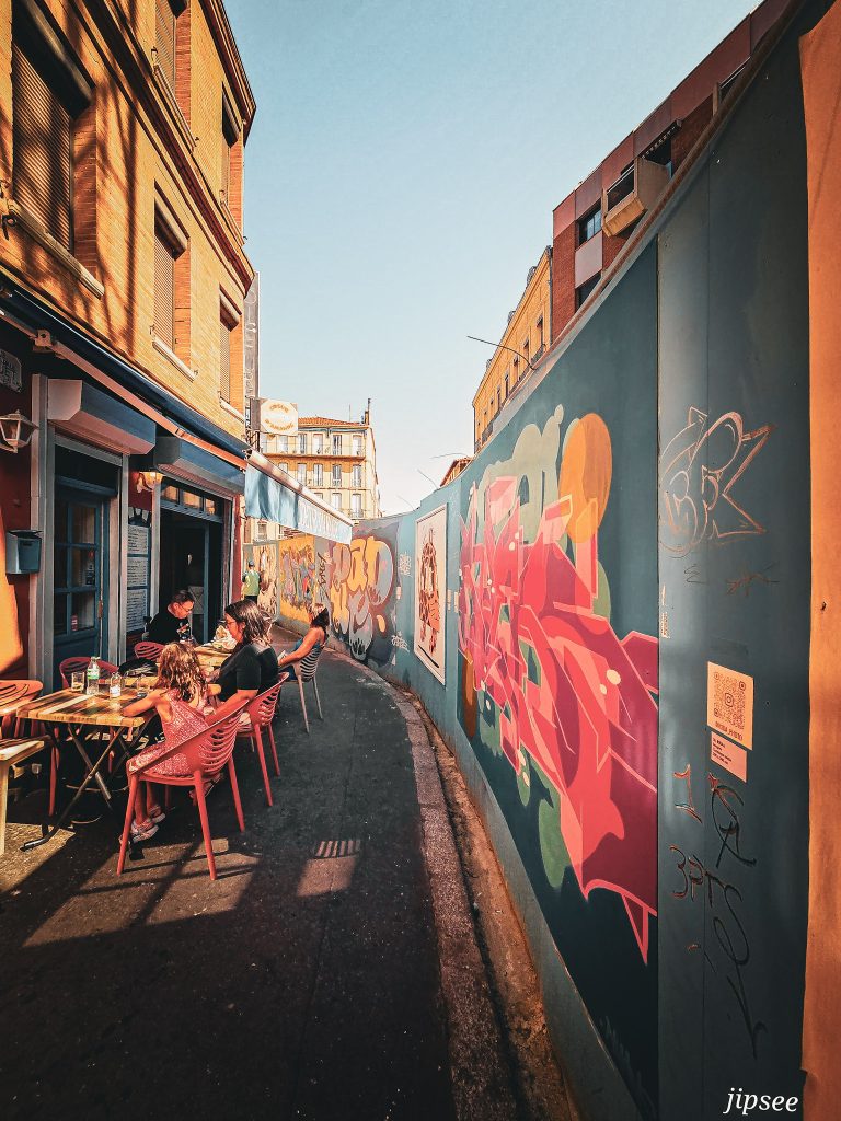 terrasse de cafe devant des oeuvres de street art dans le quartier saint aubin a toulouse