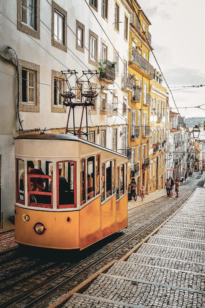 tram jaune typique dans une ruelle en pente de lisbonne