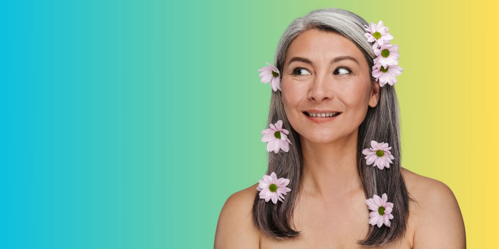 femme cheveux poivre et sel avec des fleurs dans les cheveux