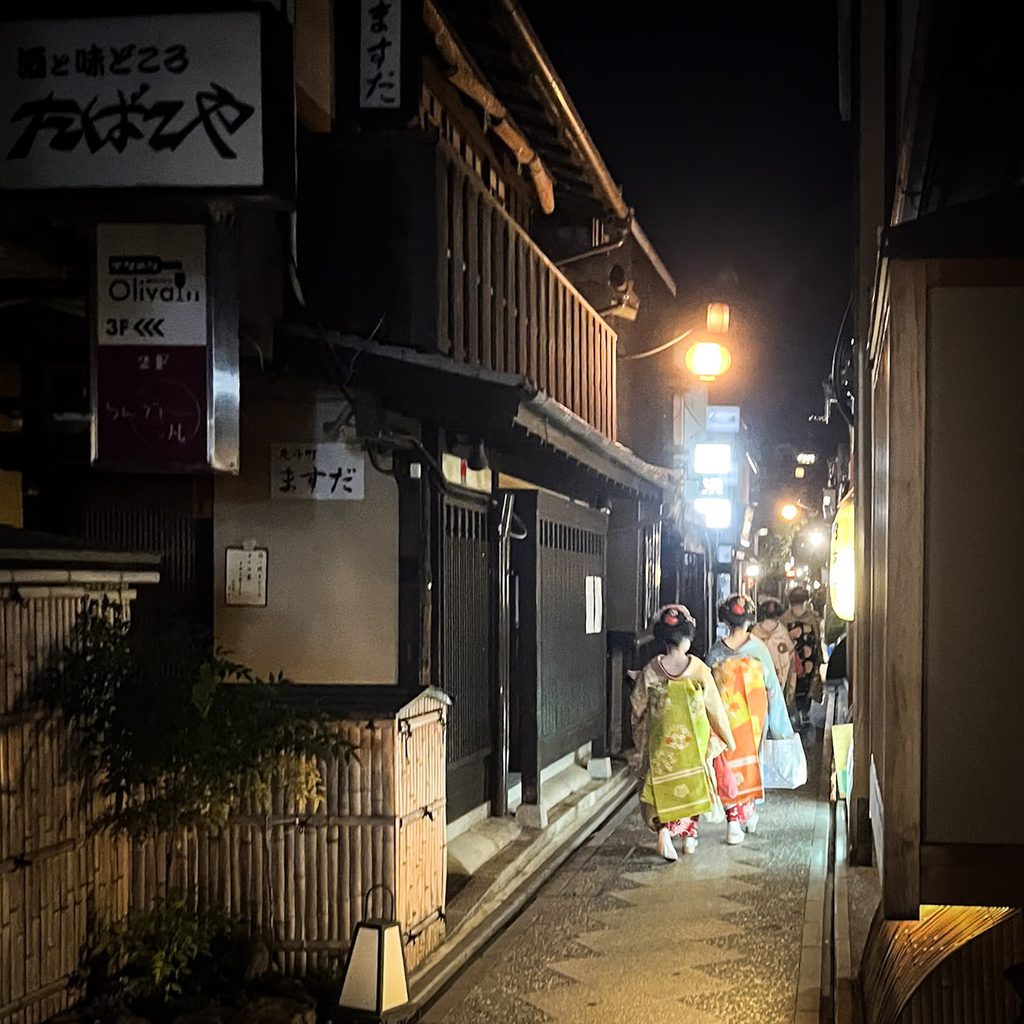 geishas de dos dans une ruelle de kyoto la nuit
