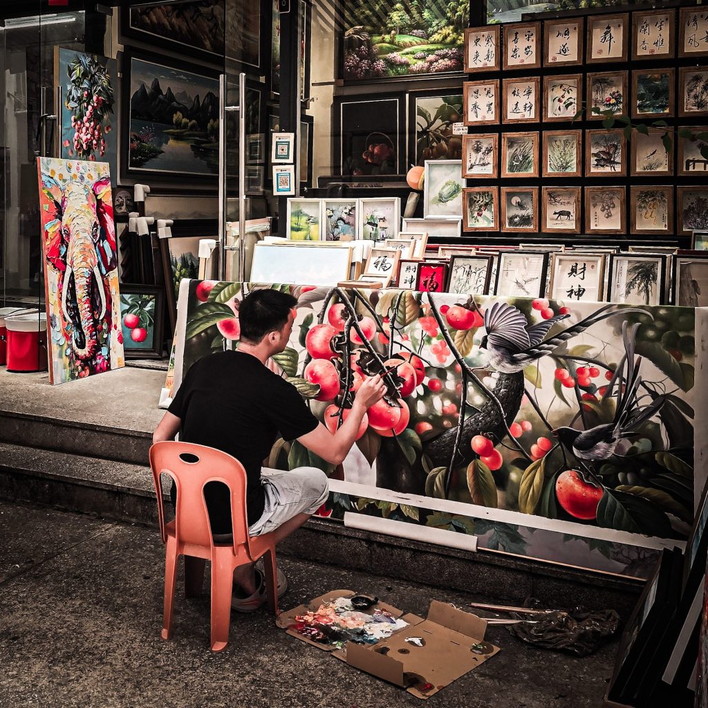 peintre en plein travail dans une ruelle de dafen painting village shenzhen